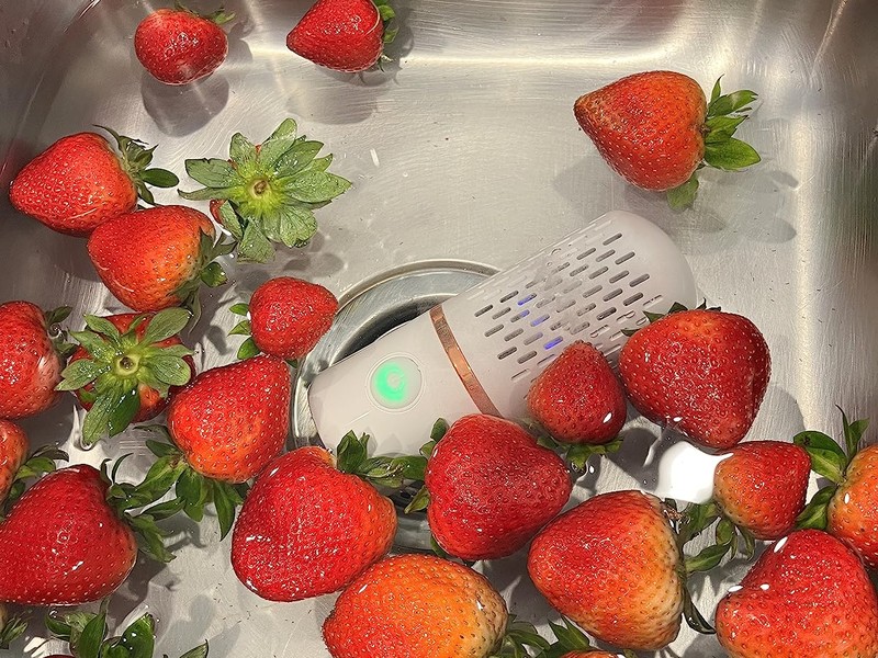 PurePod cleaning strawberries in kitchen sink
